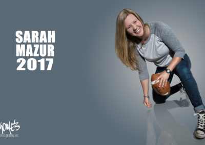 girl laughing and falling, holding football