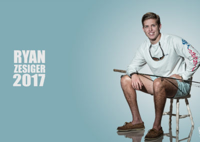 bumper shot of male teen wearing Chubbies, seated with fishing pole
